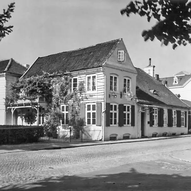 Louis C. Jacob Hotel Hamburg A house with a fence and a hedge in front.