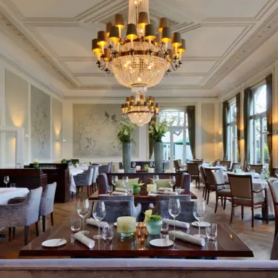 Catering A room with tables, chairs and chandeliers.