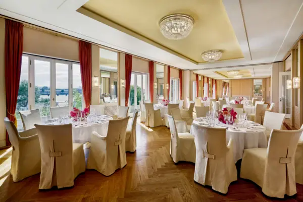 Event Venue Hamburg Louis C. Jacob An event location with round tables and large windows offering a beautiful view of the Elbe River.