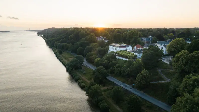 Offers & Packages A body of water with buildings and trees in the background